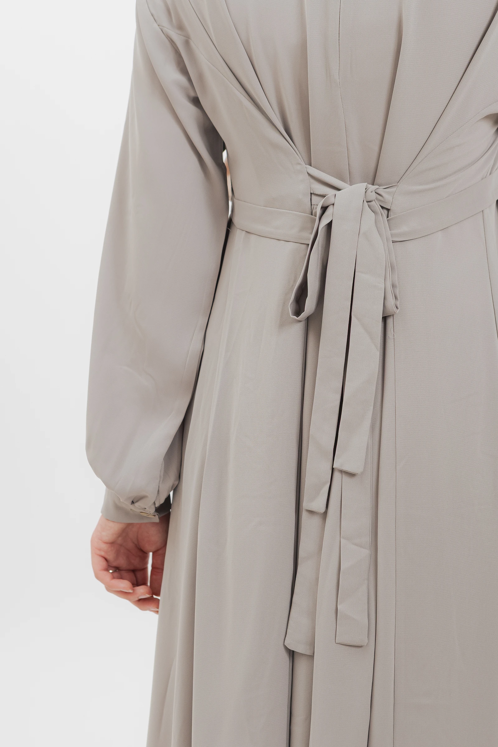 Detalle del lazo trasero del vestido modesto en gris piedra