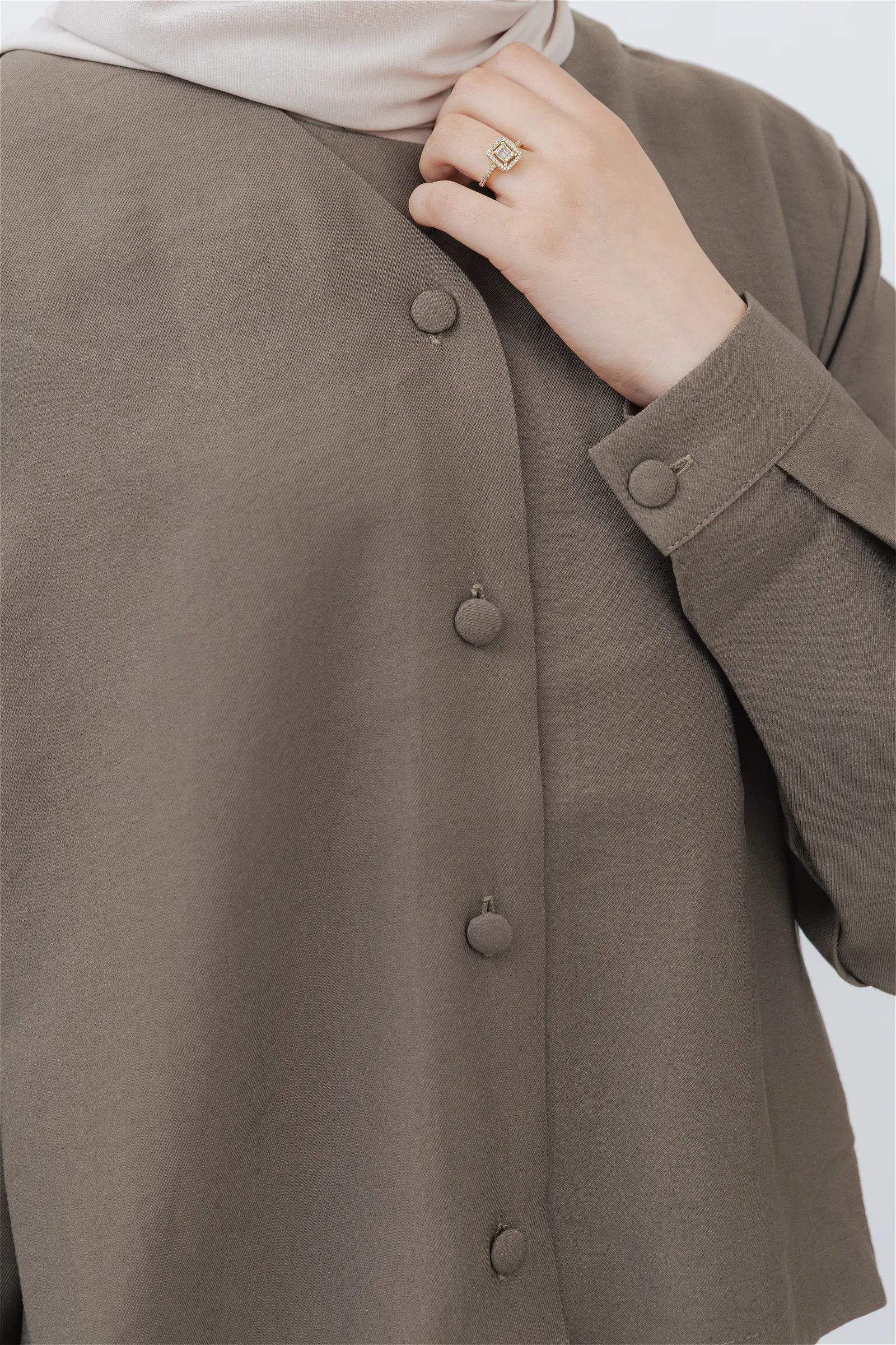 Detalle de los botones y el puño de la chaqueta del conjunto modesto modal en topo